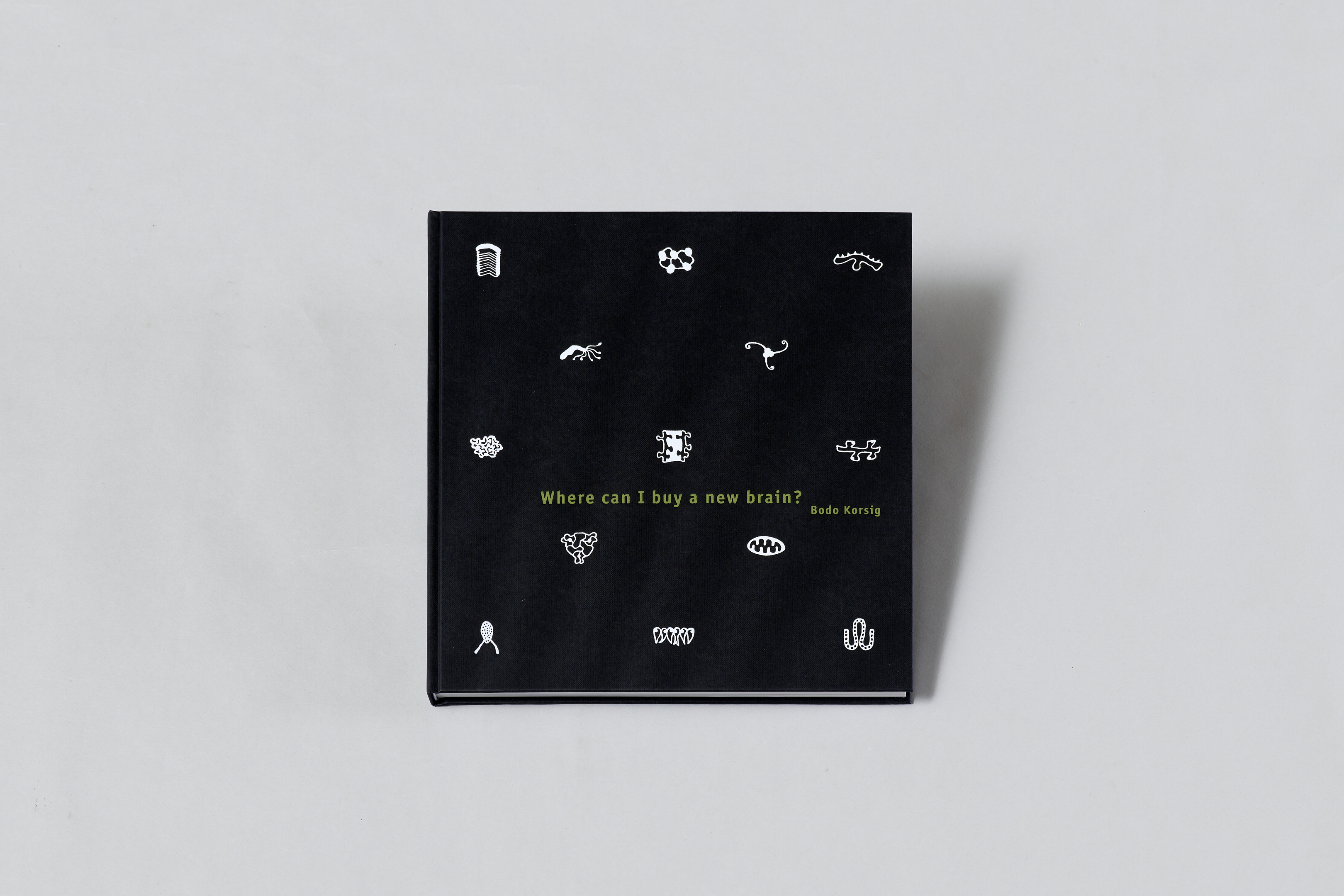AI generated: The image shows a book entitled "Where can I buy a new brain?" by Bodo Korsig, on a black background with various small white symbols.