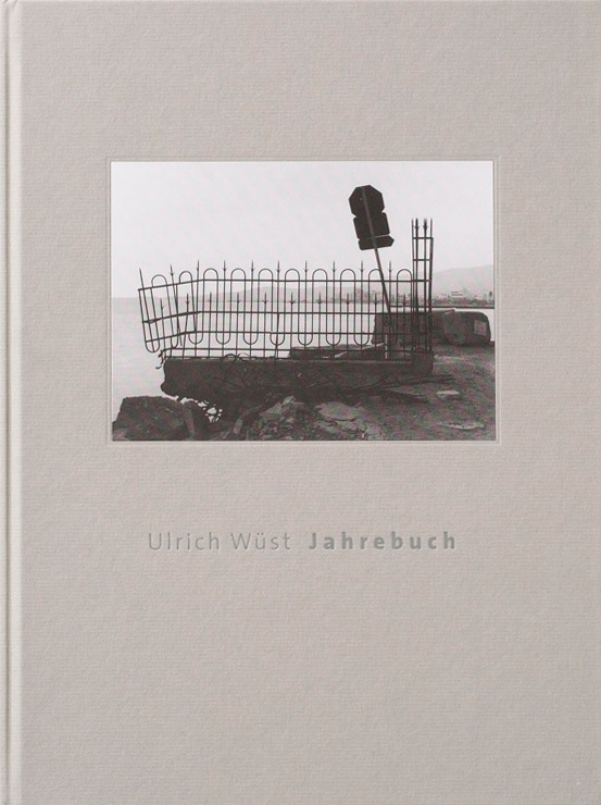 KI generiert: Das Bild zeigt das Cover eines Buches mit einem schwarz-weißen Fotografieausschnitt und den Text "Ulrich Wüst Jahrbuch". Der Hauptinhalt ist eine Aufnahme eines scheinbar verlassenen oder unvollendeten Bauwerks.