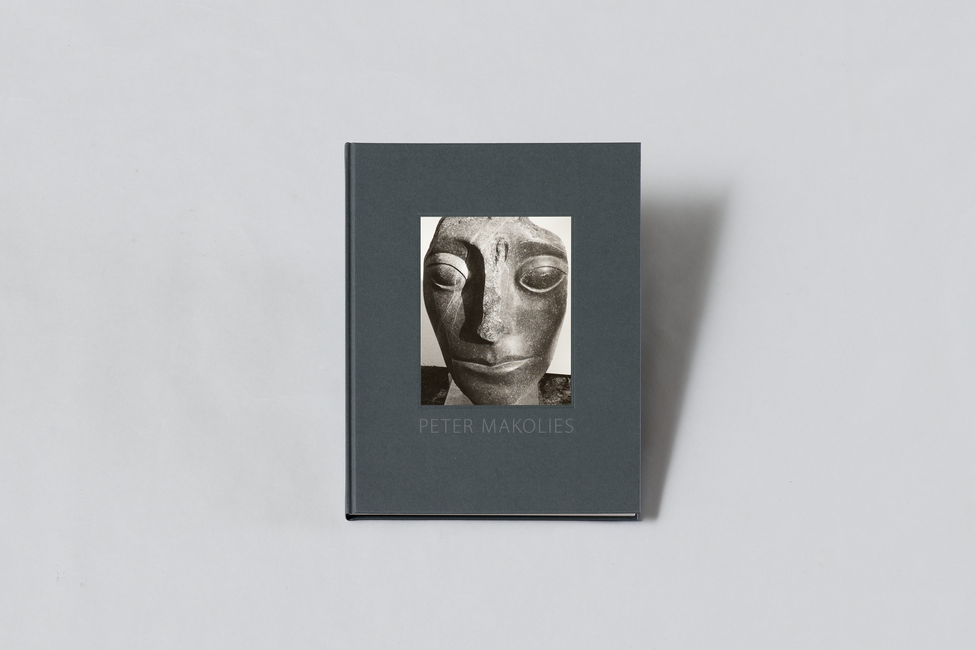 AI generated: The image shows a book with a dark cover on which a sculpture is depicted. The name "Peter Makolies" is written on it.