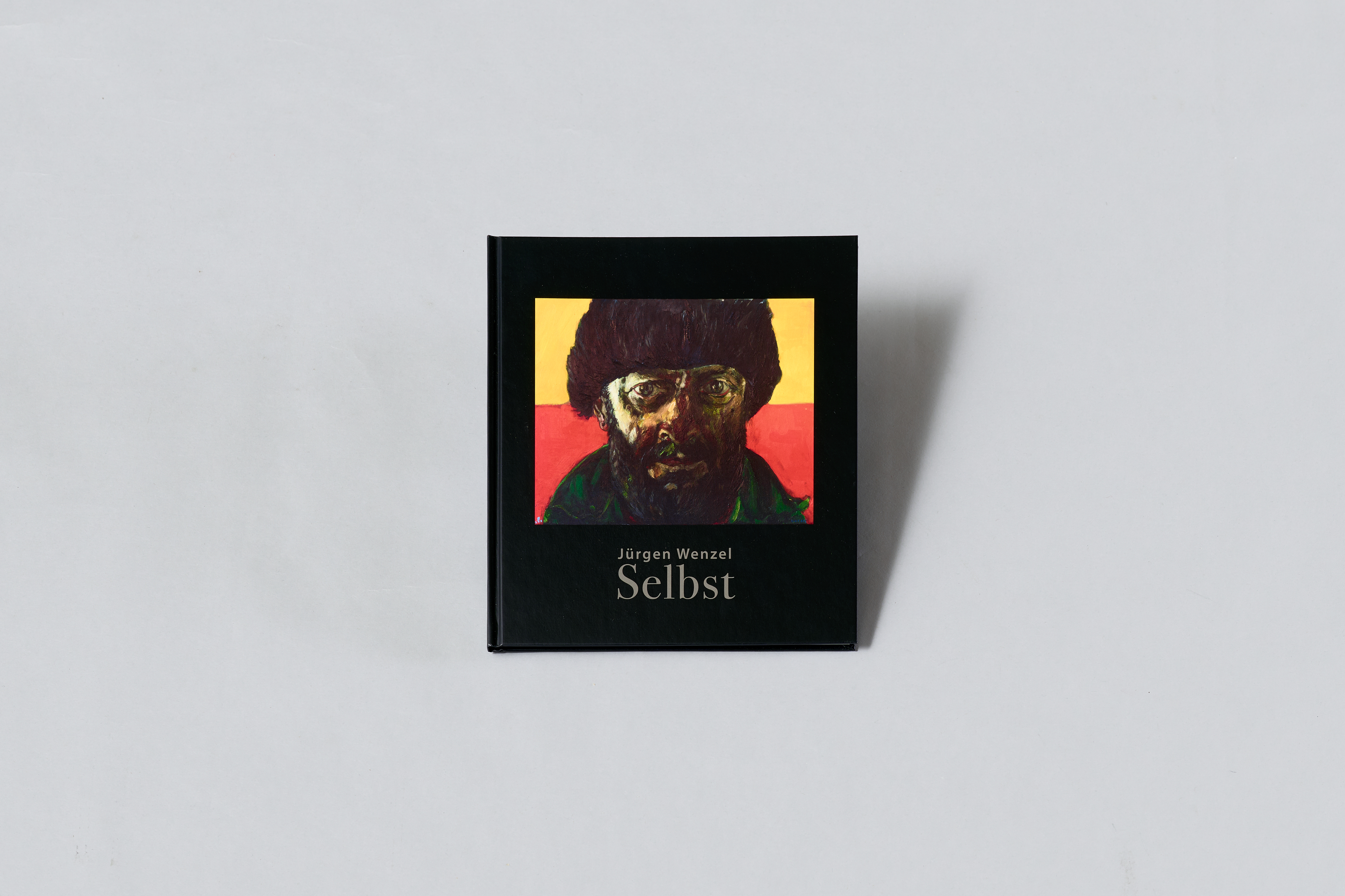 KI generiert: Das Bild zeigt ein Buch mit dem Titel "Selbst" von Jürgen Wenzel. Auf dem Cover ist ein markantes Selbstporträt abgebildet.