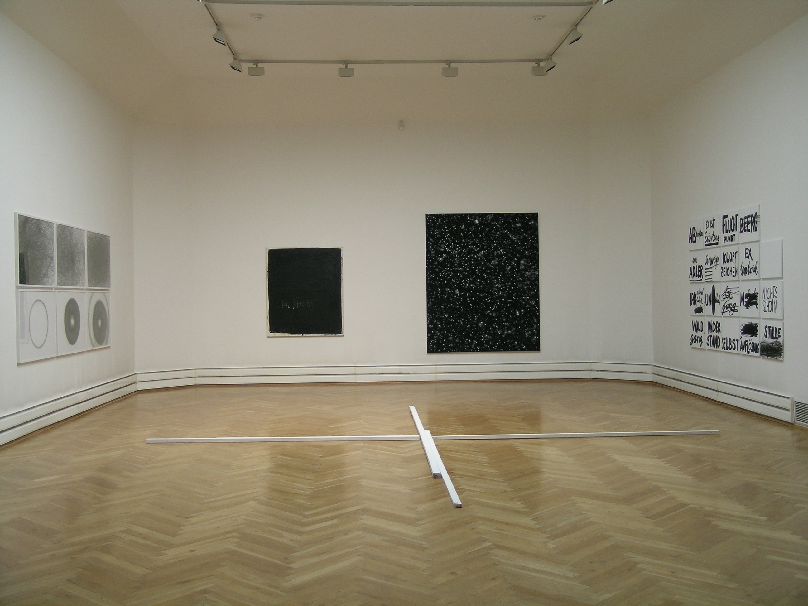 KI generiert: Das Bild zeigt einen minimalistischen Ausstellungsraum mit verschiedenen Kunstwerken an den Wänden. In der Mitte des Raums befindet sich eine skulpturale Installation aus weißen Stangen.