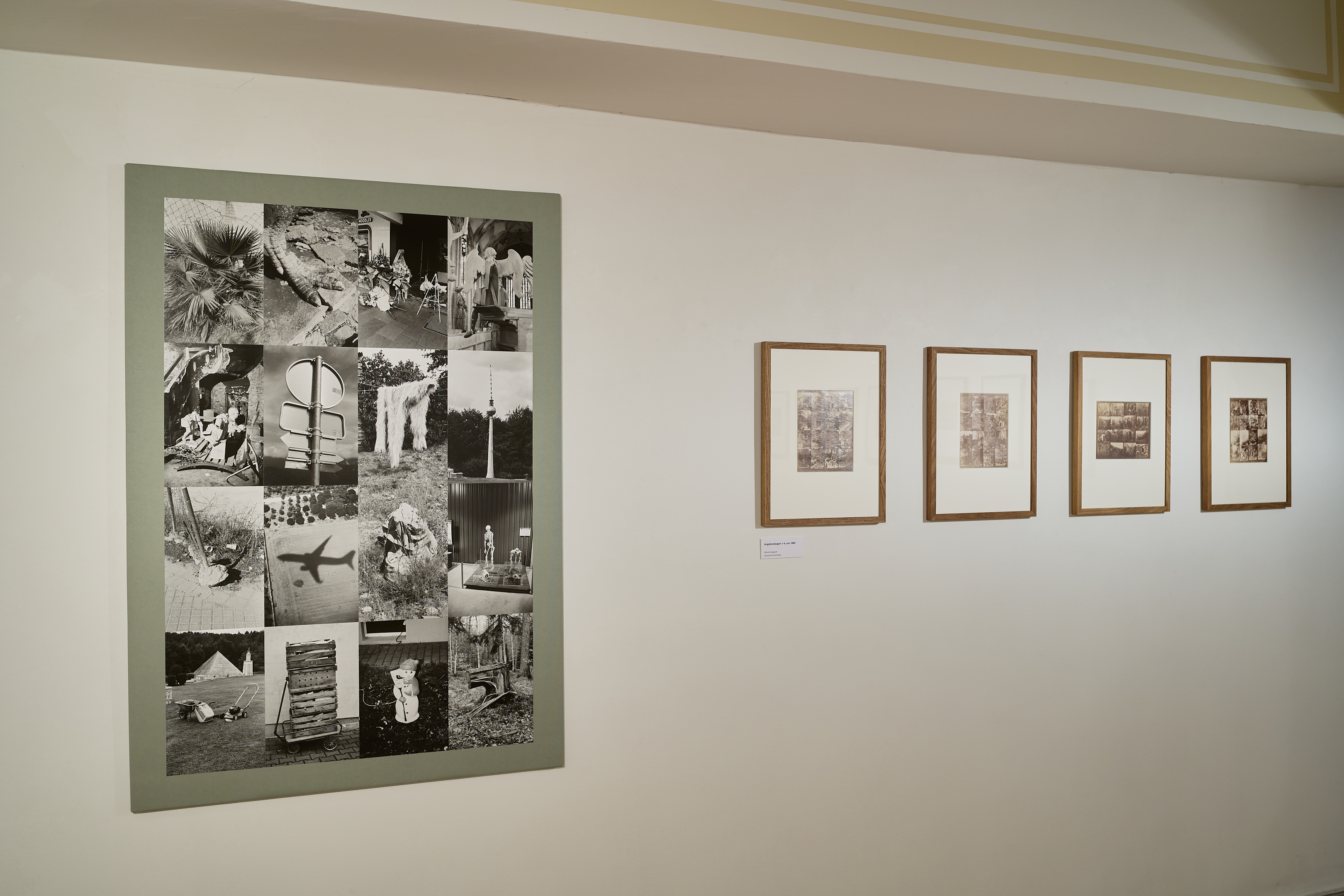 AI generated: The image shows several framed photographs on an exhibition wall, including a large composite image with various motifs in black and white. The main content is a combination of different photographs that are presented together.