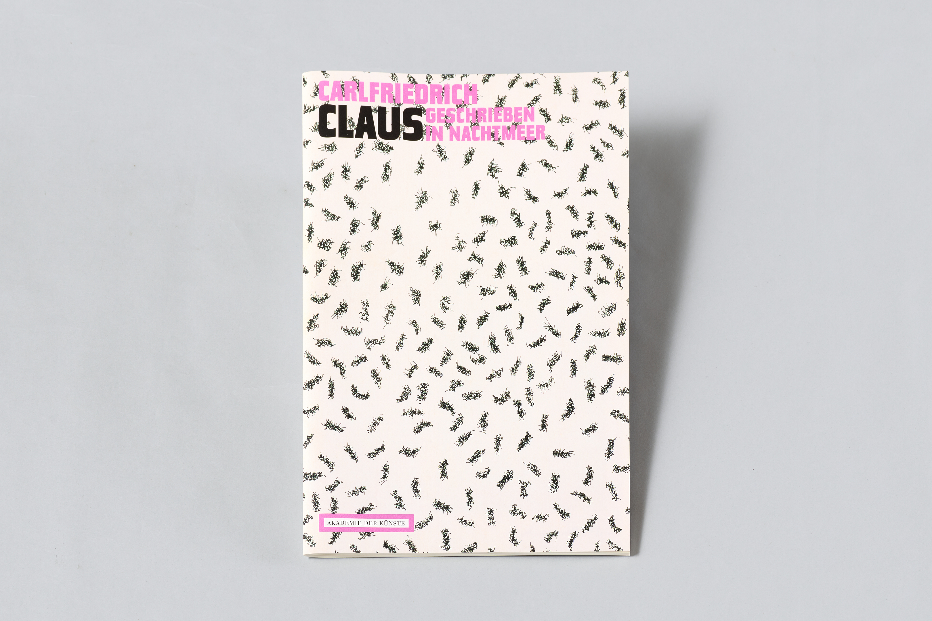 AI generated: The image shows the cover of a book by Carlfriedrich Claus entitled "Geschrieben im Nachtmeer". The background is white with a pattern of small, abstract symbols.