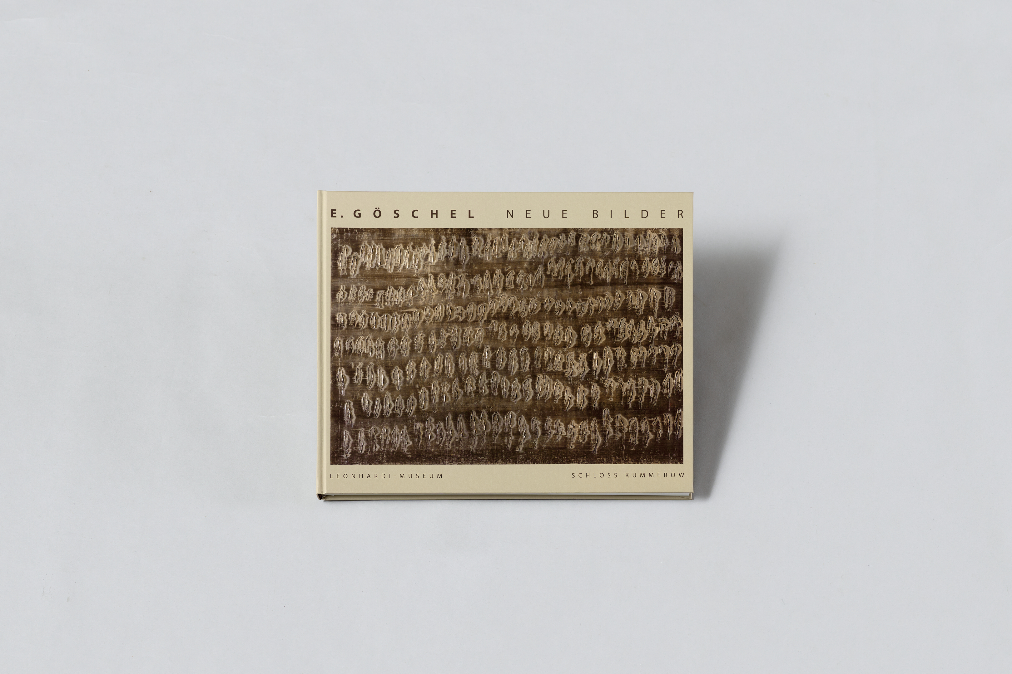 AI generated: The image shows a book with the title "E. Göschel: Neue Bilder", possibly an art catalogue. An abstract pattern can be seen on the cover, surrounded by text about the exhibition at the Leonhardi Museum and Kummerow Castle.