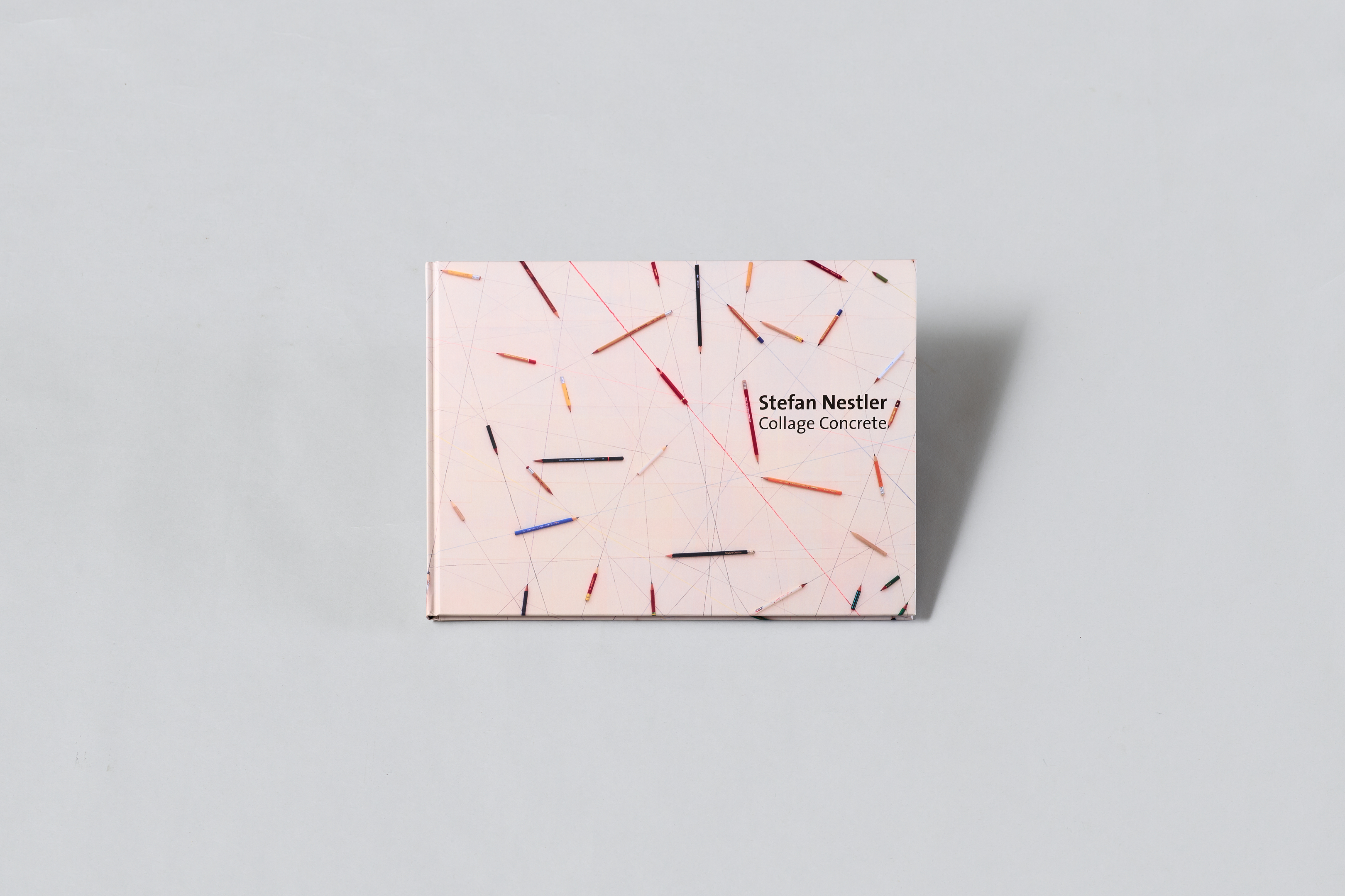 AI generated: The image shows a book with the title "Stefan Nestler / Collage Concrete" on a light grey background. The book cover is designed with colourful, diagonal lines in an abstract pattern.