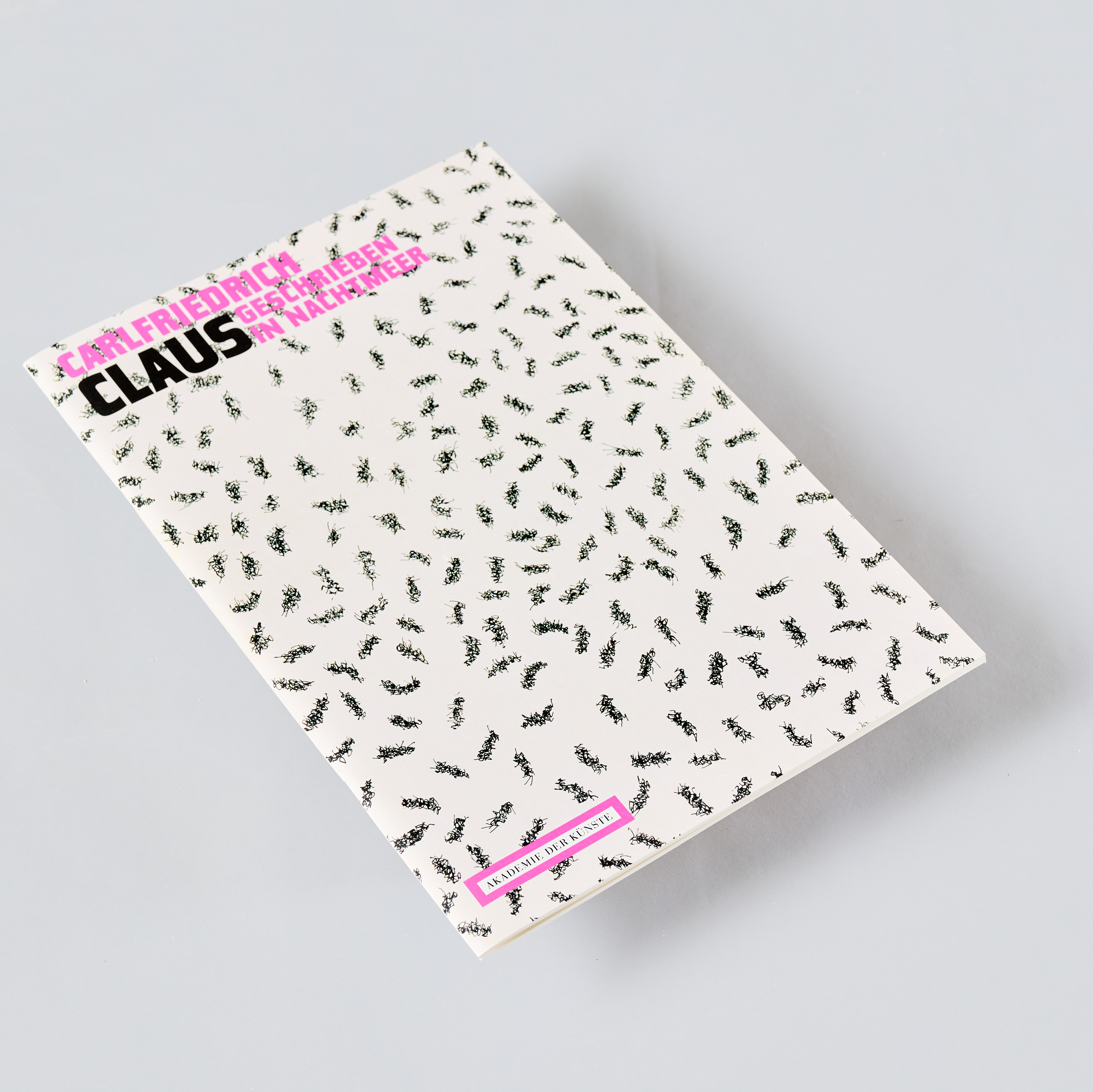 KI generiert: Das Bild zeigt ein Buch mit einem Cover, das von zahlreichen kleinen schwarzen Ameisenmotiven auf weißem Hintergrund bedeckt ist. Der Titel des Buches ist in Schwarz und Pink aufgedruckt.