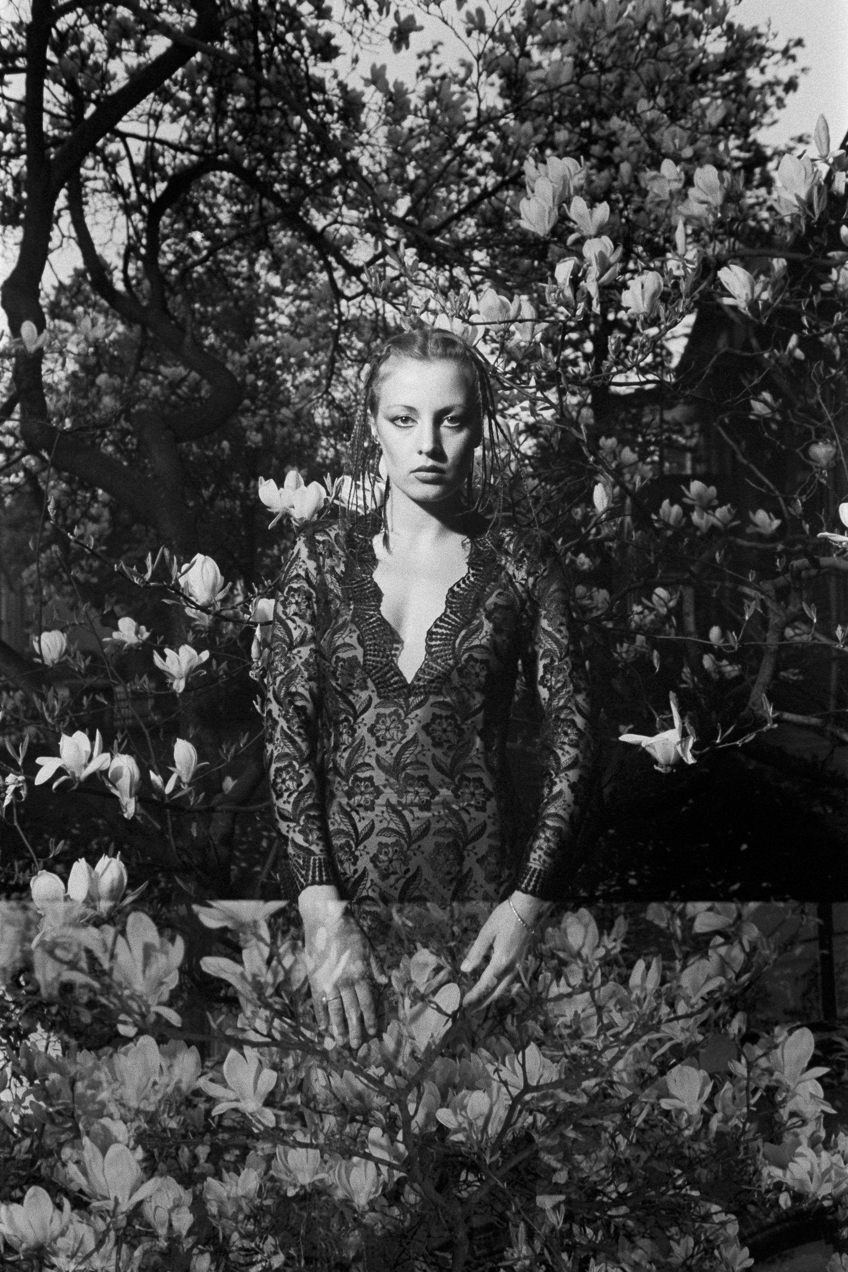 AI-generated: The image shows a person in an elegant, patterned dress, standing amongst blossoming trees. The composition conveys a harmonious connection between humanity and nature.